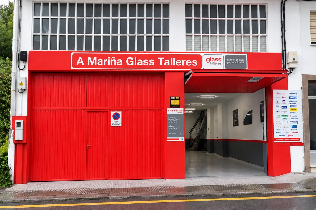 Fachada roja de A Mariña Glass Talleres y entrada del taller en Alonso Pérez, Viveiro